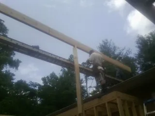 Carpenter setting a ridge beam over a new addition frame — Ice Dam Removal by Roofing Brothers in Fosston