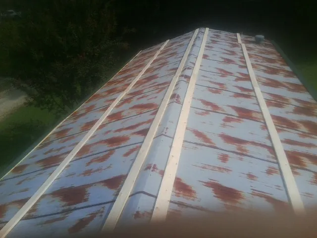 Rusted metal roof panels with new wood purlins before replacement — Storm Damage Roof Repair in Fosston by Roofing Brothers