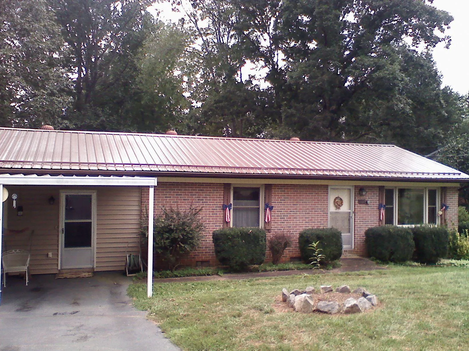 Bronze metal roof and carport on a brick ranch home — Roof Repair work by our crew in Fosston